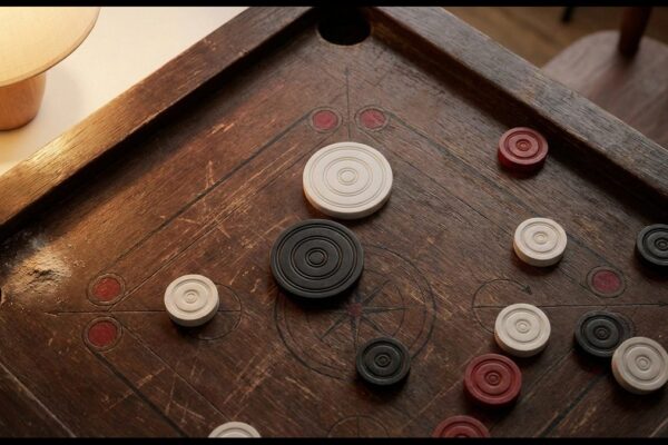 Carrom Spielbrett mit schwarzen und weißen Steinen