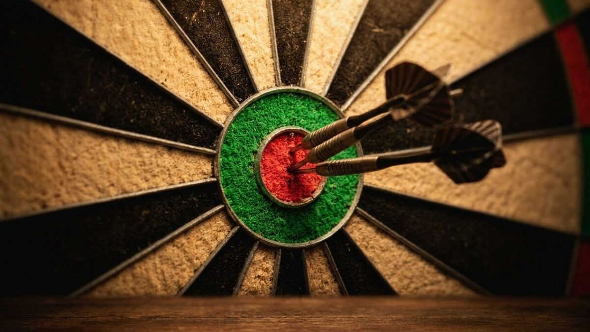 Drei Steeldarts stecken im Bullseye einer Sisal-Dartscheibe